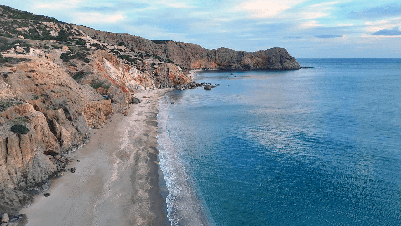 Beach framed by cliffs on the south coast of Milos