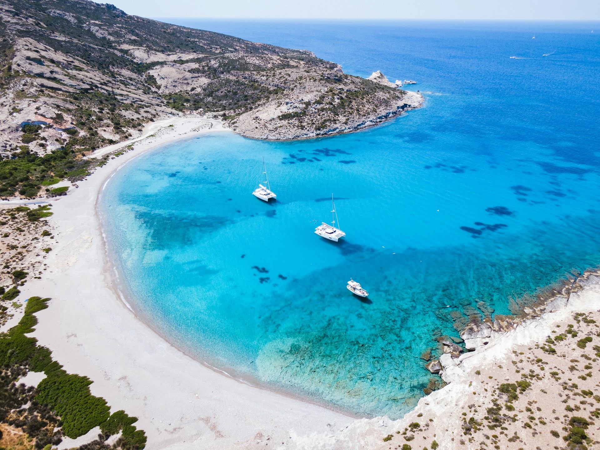 Aerial view of a turquoise bay and sandy beach on Milos